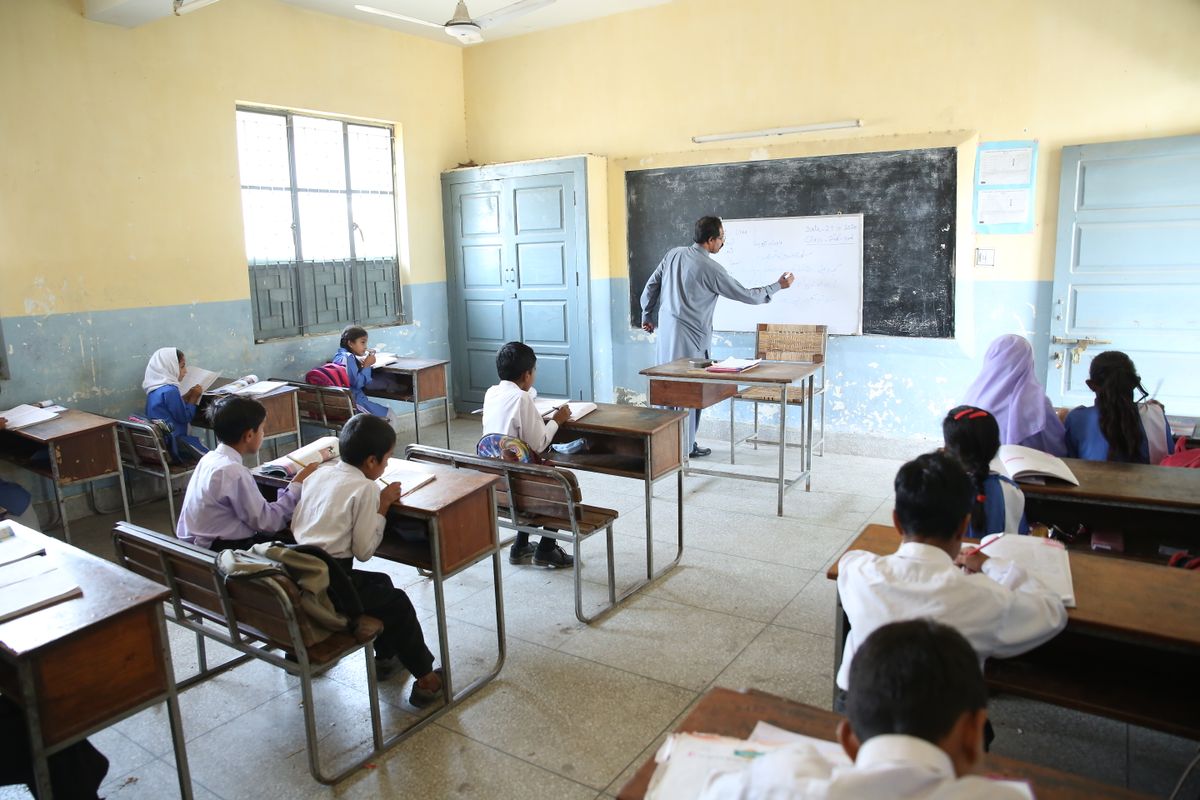 Pakistani classroom with a teacher at the blackboard and attentive students